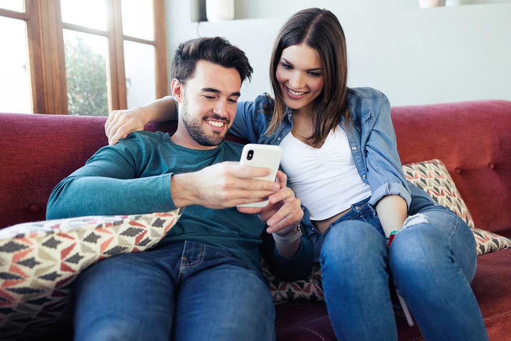 Young Couple Watching Video Production on Smartphone